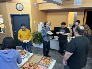 Our team eating pizza at our open doors event